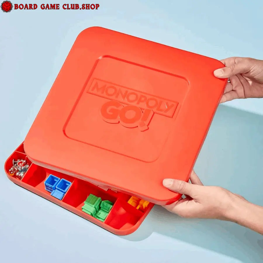 Monopoly GO board game box being opened with colorful game pieces inside for family fun