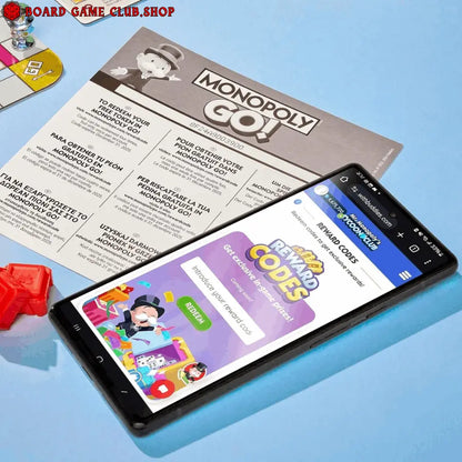 Mobile phone displaying Monopoly Go rewards page next to Monopoly Go game board and pieces